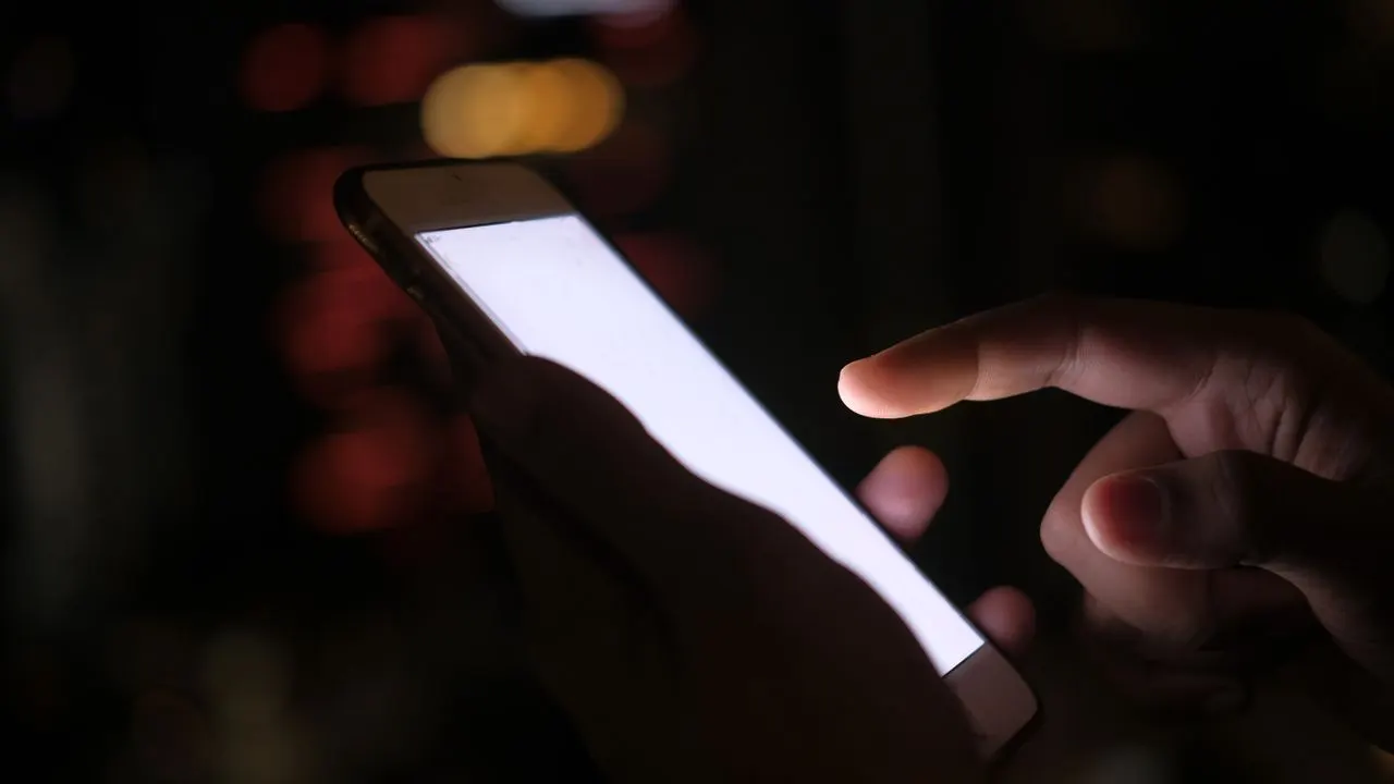 Person entscheidet am Smartphone über die Cookie-Einwilligung in einem Banner