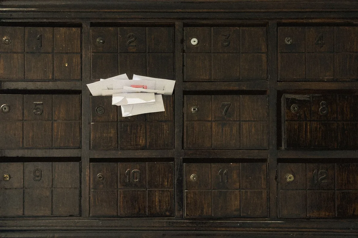 Alte hölzerne Briefkastenwand mit nummerierten Fächern: Post von nic.at geht an die Adresse im Whois, auch wenn dort die Agentur steht