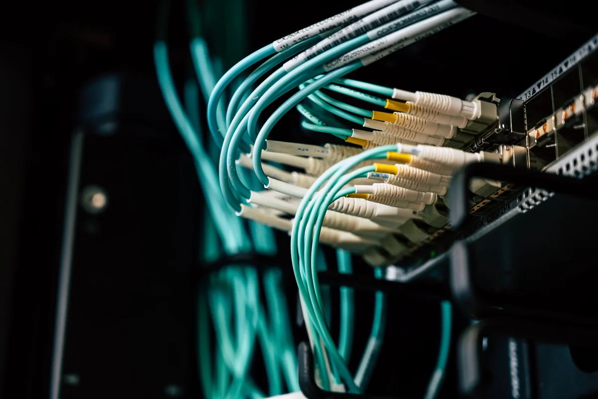 Glasfaserkabel stecken dicht an dicht in einem dunklen Serverschrank: Auf solchen Servern läuft PHP, und dort wird das Sicherheitsupdate gegen PHP2Shell eingespielt