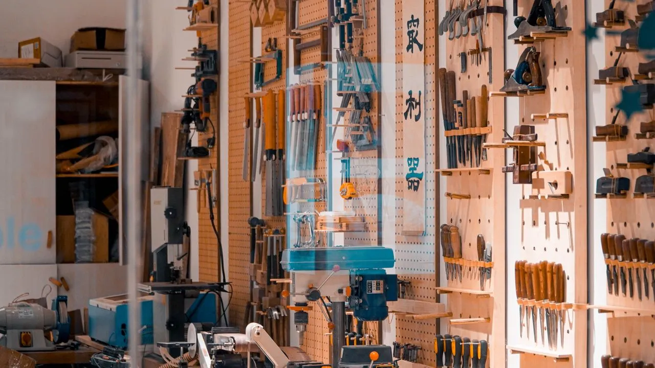 Werkstatt eines kleinen Handwerksbetriebs mit ordentlich aufgehängtem Werkzeug an der Wand