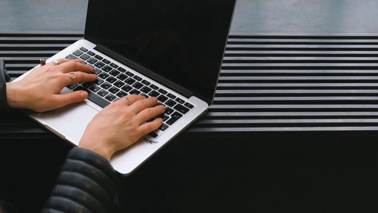 Hände tippen konzentriert an einem Laptop als Sinnbild für die fokussierte Website-Erstellung an einem Tag