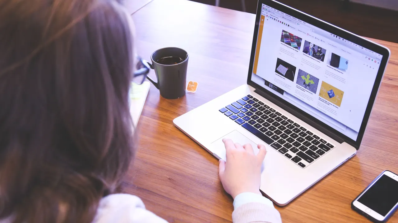 Unternehmerin sieht sich am Laptop ihre fertige Website an, die sie zum Fixpreis erstellen ließ