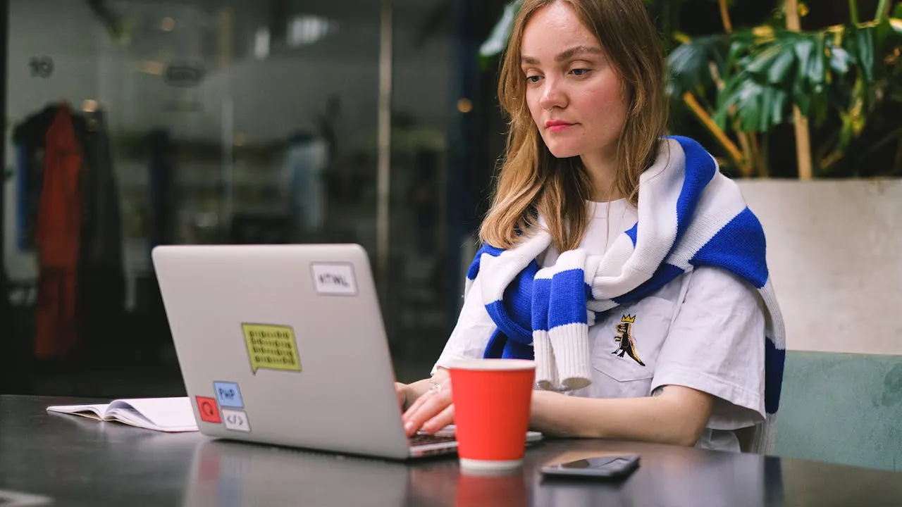 Web-Designerin am Laptop, Vergleich Website selbst erstellen oder erstellen lassen
