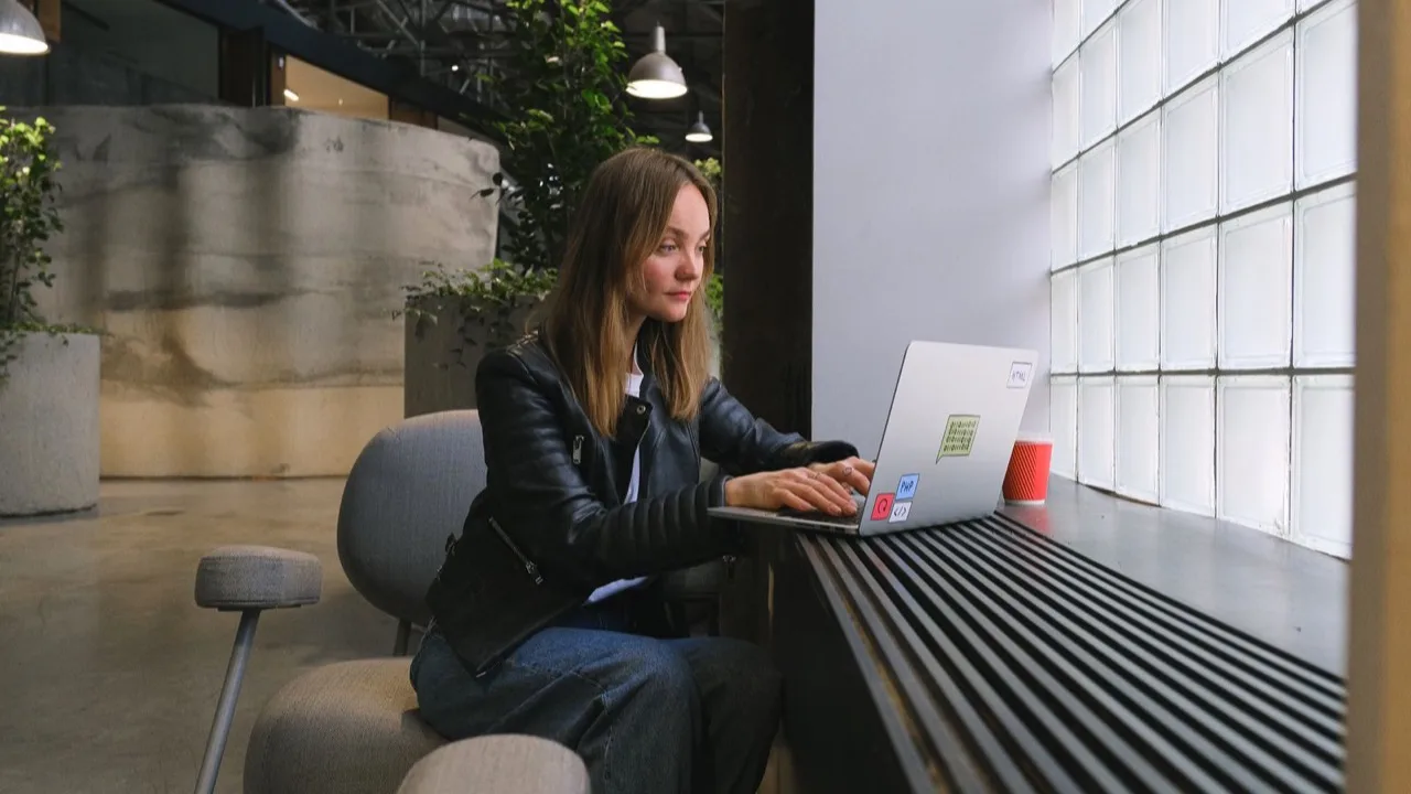 Person arbeitet konzentriert am Laptop in einem hellen, modernen Büro als Sinnbild für professionelle Website-Erstellung