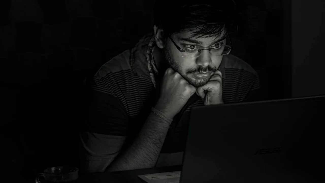 Person sitzt spätabends konzentriert vor dem Laptop, monochromes Bild als Sinnbild für den hohen Zeitaufwand beim Selberbauen