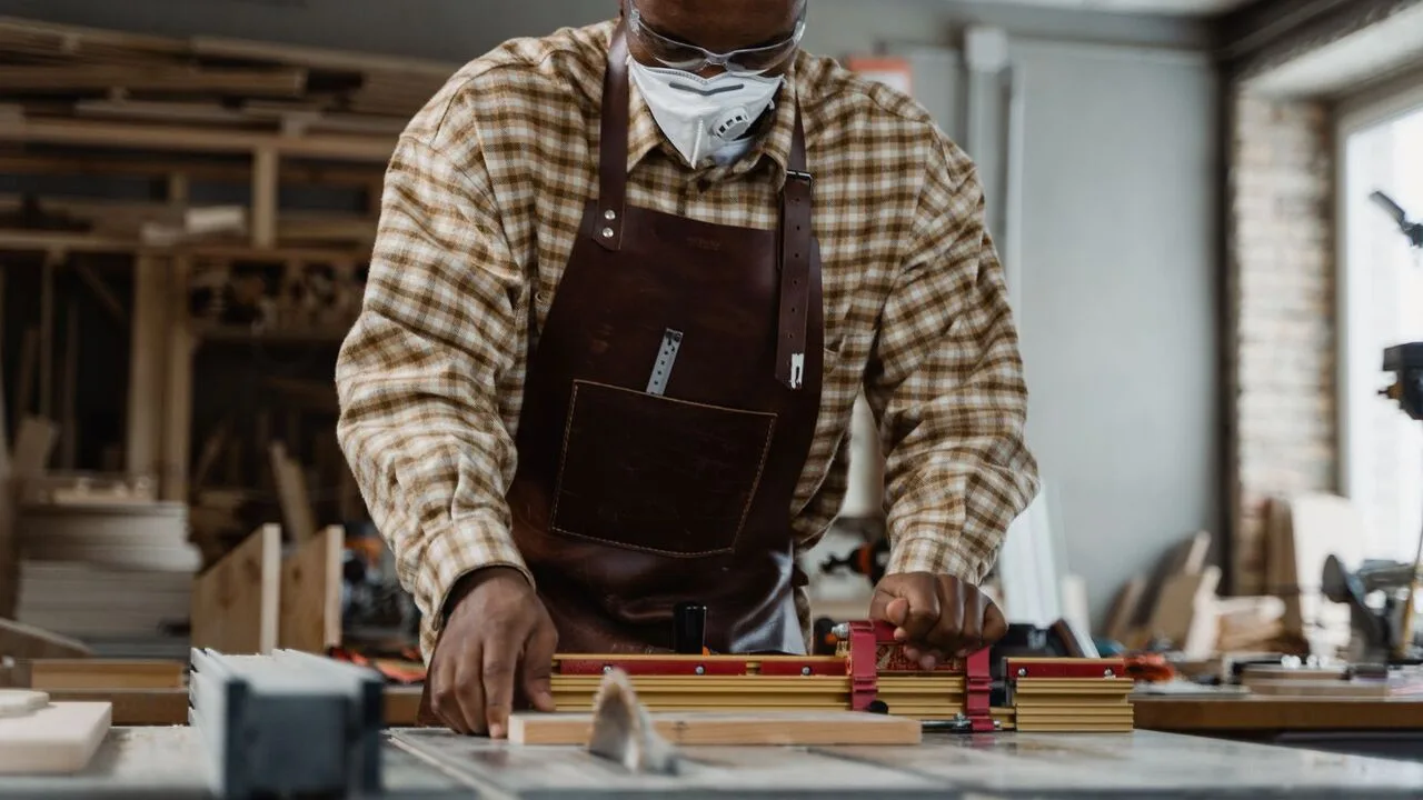 Tischler arbeitet konzentriert in seiner Werkstatt, typischer Kleinbetrieb mit begrenztem Werbebudget